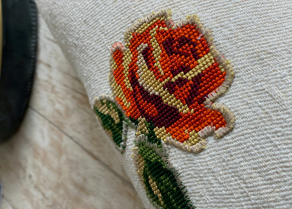 détail motif de fleur rose orangée de canevas appliqué au surjet sur un coussin décoratif 