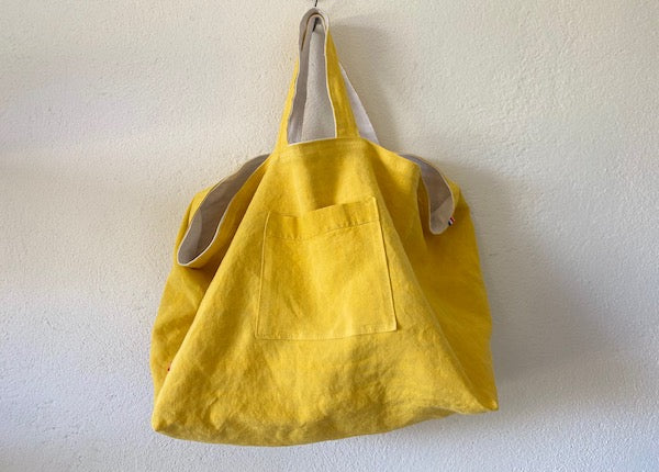 sac cabas upcyclé entièrement réversible. Un côté en lin ou chanvre ancien couleur naturel et une poche en canevas recyclé. Un côté uni de couleur jaune et une poche ton sur ton.