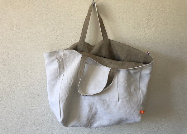 sac cabas entièrement réversible. Un côté en lin ou chanvre ancien couleur naturel et une poche en canevas recyclé. Un côté uni de couleur blanc naturel et une poche ton sur ton.