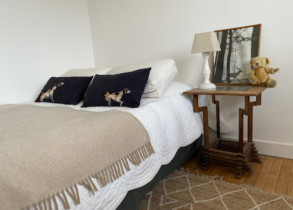 sur un lit, une paire de coussins décoratifs en lin ancien teint noir et canevas recyclé appliqué au surjet motif chien setter